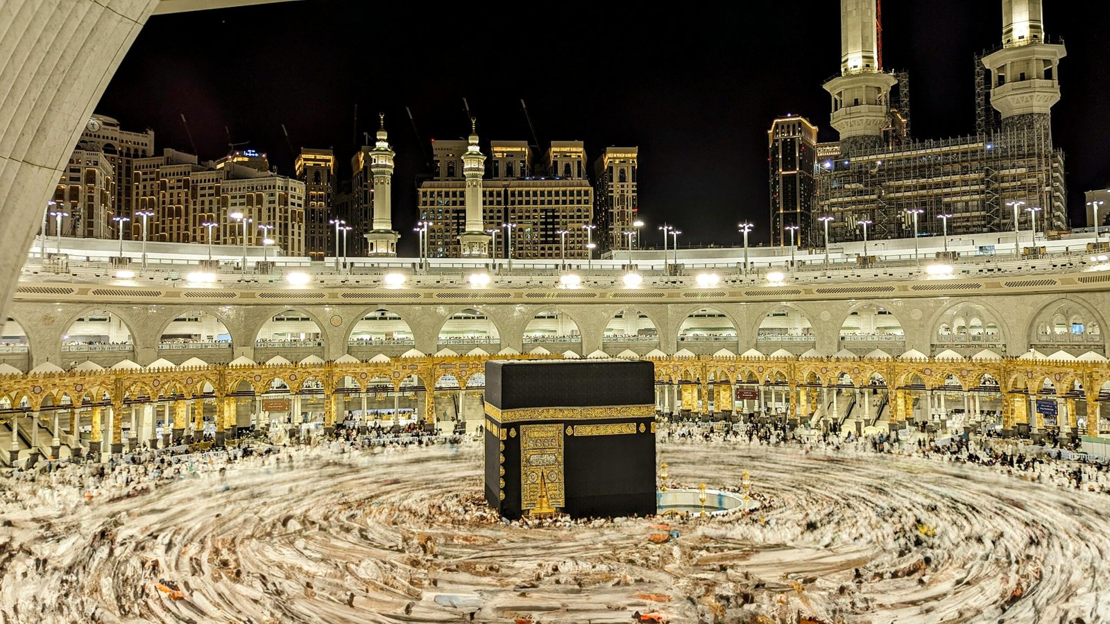 Tourism Vibrant night view of the Kaaba in Mecca, capturing Islamic architecture and worshippers.