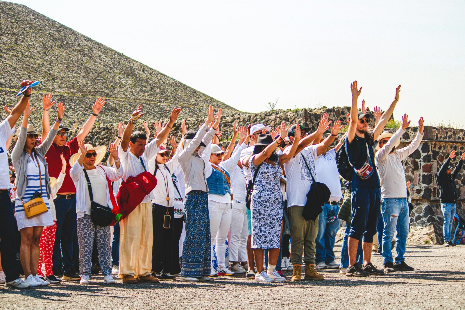 Tourism A group of tourists raising hands at the Pyramids of Teotihuacán, Mexico.